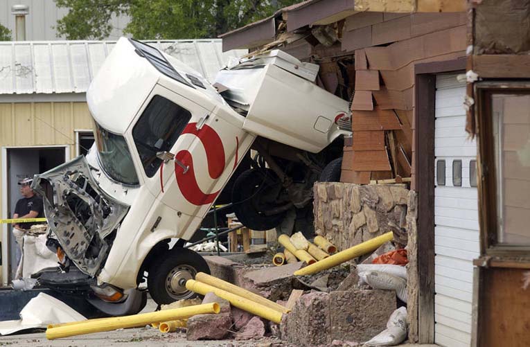Разрушенный грузовик Xcel застрял в здании Mountain Parks Electric в результате неистовства Марвина Химейера на бронированном бульдозере