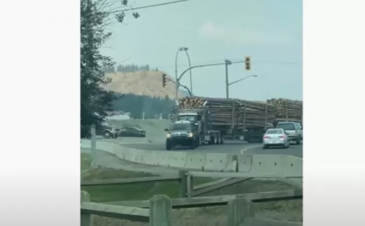 Обычный автомобиль тащит грузовик, который тащит два прицепа с лесом (ВИДЕО)